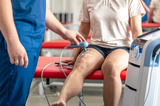 Foto médico que utiliza una máquina para tratar las articulaciones de la rodilla de un paciente