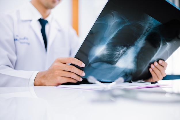 Foto médico radiologista examinando uma radiografia de tórax de um paciente na clínica de saúde