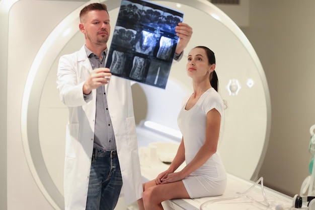 Foto médico radiologista observando um instantâneo da coluna do paciente em frente à hérnia espinhal da máquina de ressonância magnética