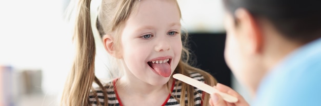 Médico realiza un examen físico de la garganta de la niña