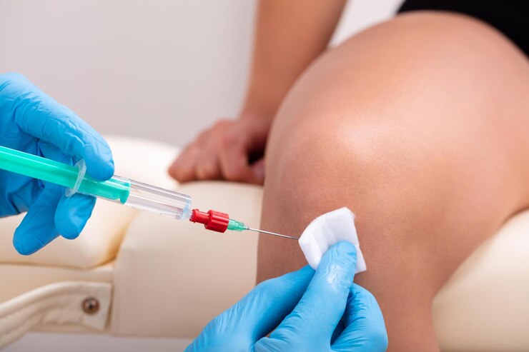 Foto el médico realiza una inyección de belleza rejuvenecedora en la rodilla de una mujer
