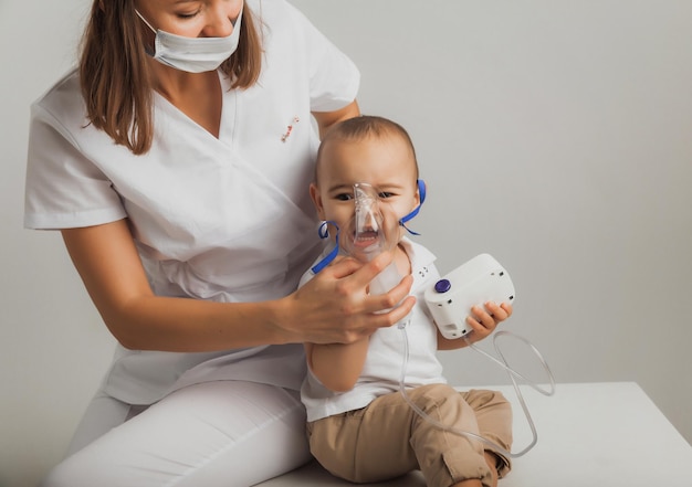 El médico realiza un procedimiento de inhalación para un niño pequeño. Foto de estudio de alta calidad. medicina para niños