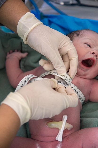 Foto médico realizando procedimento de medição em recém-nascido