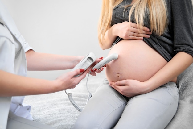 Médico realizando ultrassom em sua paciente grávida