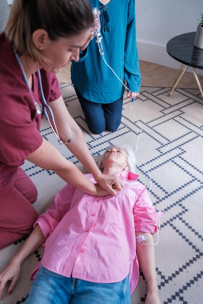 Foto médico realizando uma massagem cardíaca para resgatar uma mulher em casa hospital de medicina conceitual