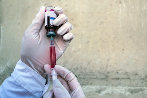 Foto el médico recoge la vacuna en una jeringa.