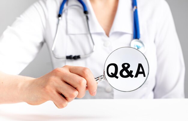 Médico responde a perguntas de pacientes sobre cuidados médicos FAQ no conceito de saúde e medicina Mulher com estetoscópio em jaleco segurando lupa com letras qa