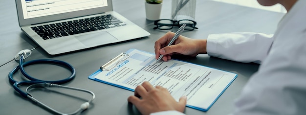 Foto el médico revisa cuidadosamente el informe médico detallado en la computadora portátil y diagnostica la enfermedad para un plan de tratamiento de atención médica eficaz para el paciente en el consultorio del médico evaluación médica profesional neoteric