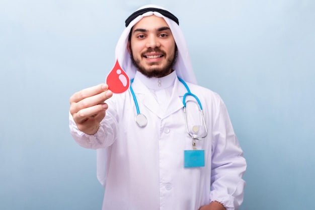 Médico saudita muestra la figura de una gota de sangre Concepto de donación de sangre