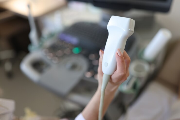 Foto médico segurando a sonda de ultrassom na mão em close da clínica