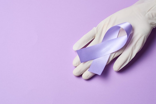 Médico segurando fita roxa no dia mundial do câncer, 4 de fevereiro, em roxo plano
