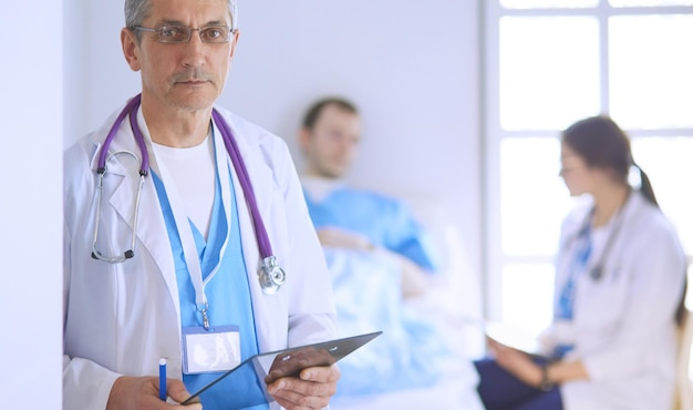 Médico segurando pasta na frente de um paciente e um médico