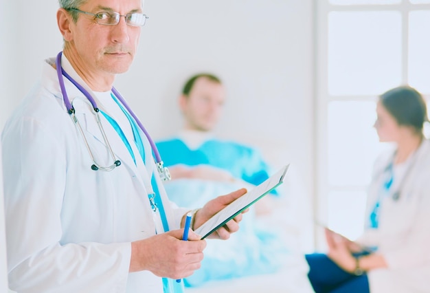 Médico segurando pasta na frente de um paciente e um médico