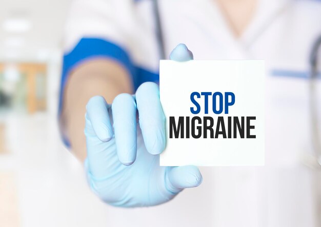Médico segurando um cartão com o texto Stop Migraine conceito médico