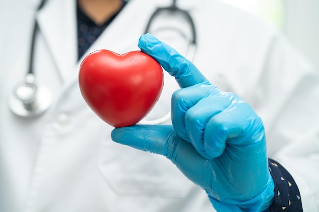 Médico segurando um coração vermelho na enfermaria do hospital conceito médico forte saudável