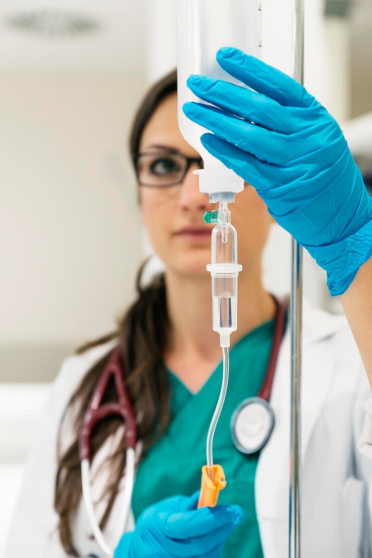 Foto médico segurando um gotejador enquanto está de pé no hospital