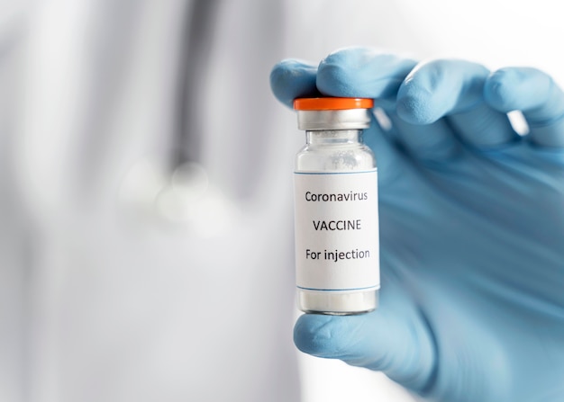 Foto médico segurando um recipiente de vacina contra o coronavírus em close-up da mão