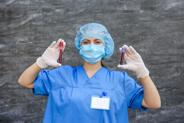 Médico segurando um tubo de ensaio vermelho e olhando para ele no laboratório