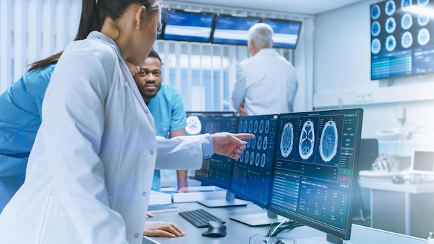 Un médico señala un escáner cerebral en la pantalla de una computadora.