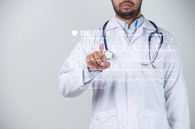 Un médico señala una pantalla de frecuencia cardíaca con un estetoscopio.