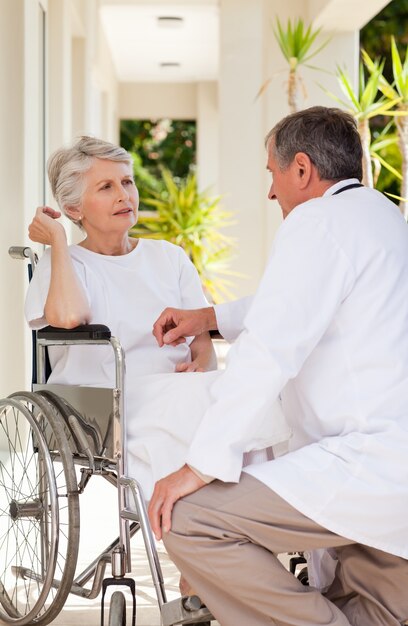 Médico Senior hablando con su paciente