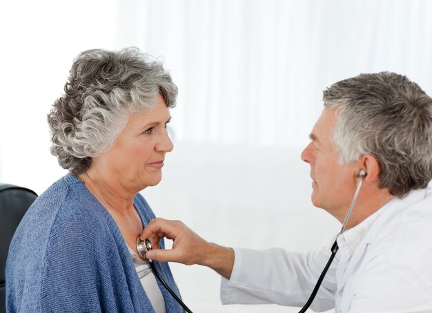 Un médico senior haciendo un examen de su paciente.