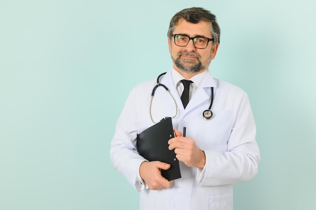 Médico senior hombre vestido con estetoscopio y bata médica sobre fondo azul Expresión alegre