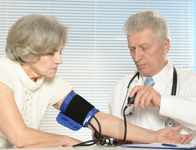 Foto médico senior con un paciente anciano en su oficina