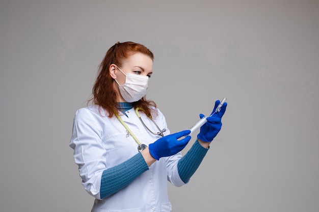 Médico seringa de enchimento com vacina. Médico profissional com cabelo vermelho