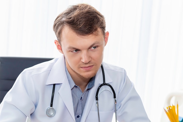 Médico sério homem sentado no quarto do hospital.