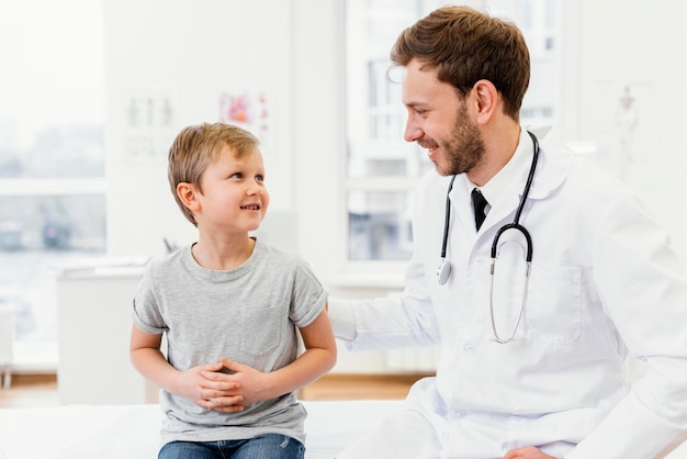 Foto médico sorridente e paciente de tiro médio