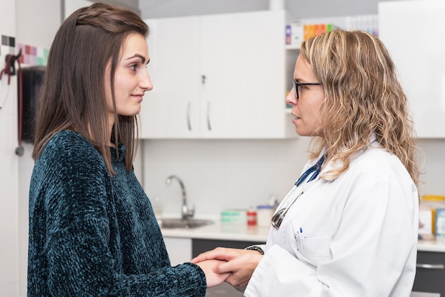 Médico sosteniendo las manos del paciente, concepto de ayuda y empatía.