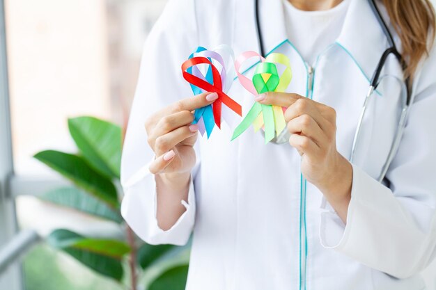 El médico sostiene cintas de colores que simbolizan la conciencia de diversas enfermedades.