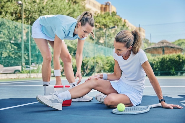 Médico de tenis con primeros auxilios y mujer con dolor de rodilla, músculo desgarrado o inflamación en la cancha mientras entrena Entrenador femenino mentor o atleta de ayuda con tensión tierna o pierna rota con fitness al aire libre