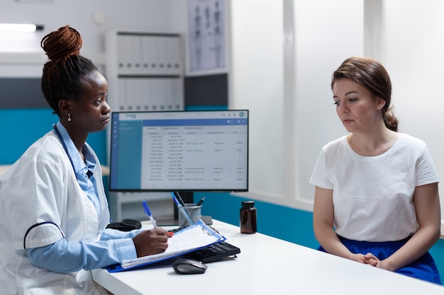 Médico terapeuta afro-americano discutindo sintomas da doença