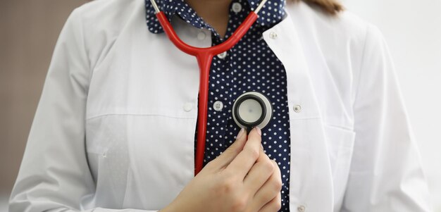 Foto médico terapeuta segurando um estetoscópio perto de seu peito em close-up