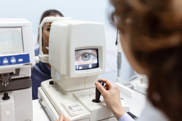 Médico testando os olhos com aparelhos ópticos especiais na clínica moderna oftalmologista examinando os olhos