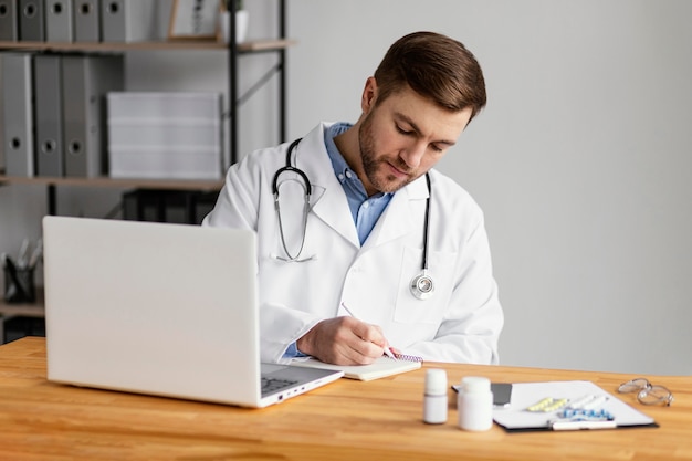 Médico de tiro medio escribiendo prescripción