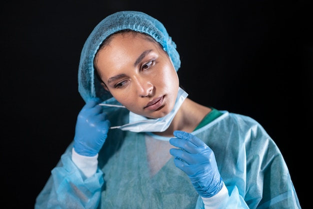 Foto médico de tiro medio quitándose la máscara