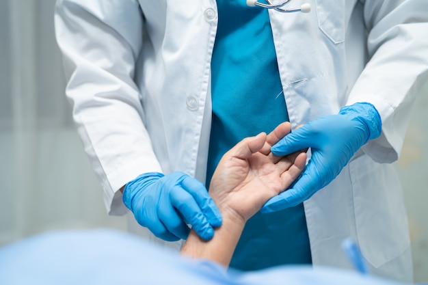 Médico tomar el pulso con el paciente en el hospital de enfermería.