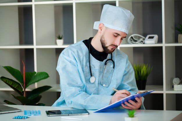 Médico trabalha em uma mesa no consultório da clínica.