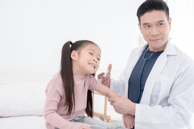 Foto el médico trata al niño mediante inyección.