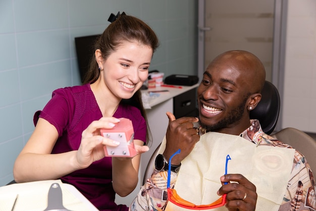 Médico trata dentes de pacientes em clínica odontológica moderna