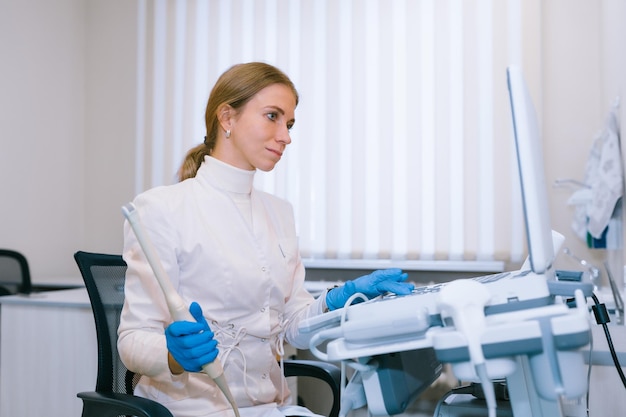 El médico de ultrasonido en la oficina de la clínica realiza un estudio del sistema genitourinario