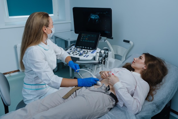 El médico de ultrasonido realiza un control de salud anual de un paciente joven Examen de órganos abdominales con la ayuda de equipos modernos en la clínica