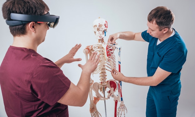 Médico usa óculos de realidade aumentada e esqueleto humano para ensinar aluno