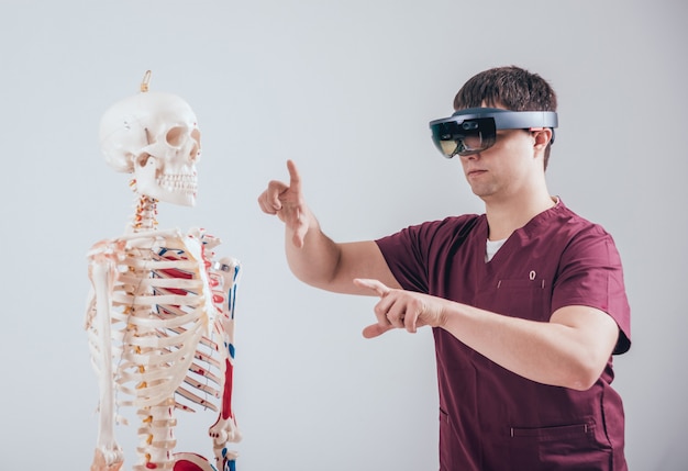 Médico usa óculos de realidade aumentada para examinar esqueleto humano