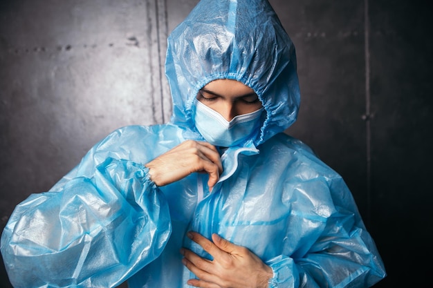 Médico usa roupa de proteção e máscara azul