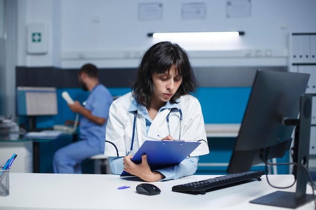 Médico usando clipboard no escritório da clínica
