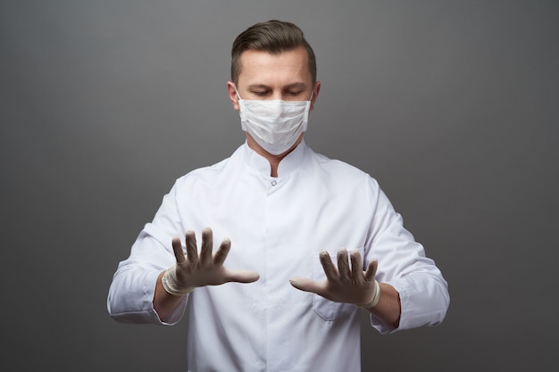 Médico usando luvas de látex protetoras e máscara facial